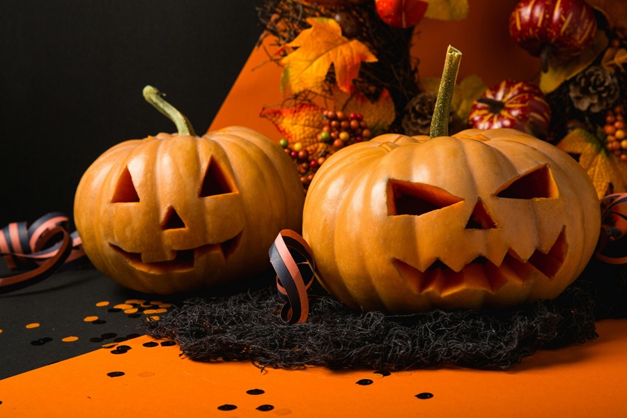 Instant Pot Halloween Recipes Close Up of Two Jack-O-Lanterns on an Orange Surface with Black Accents
