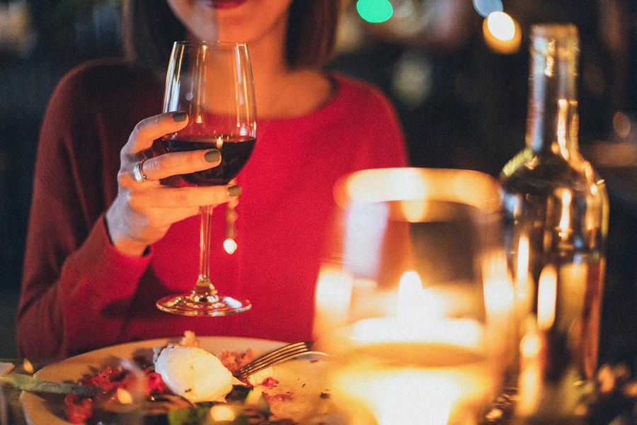 Romantic Instant Pot Recipes for Two a Woman Sitting at a Table Smiling with Candles on the Table