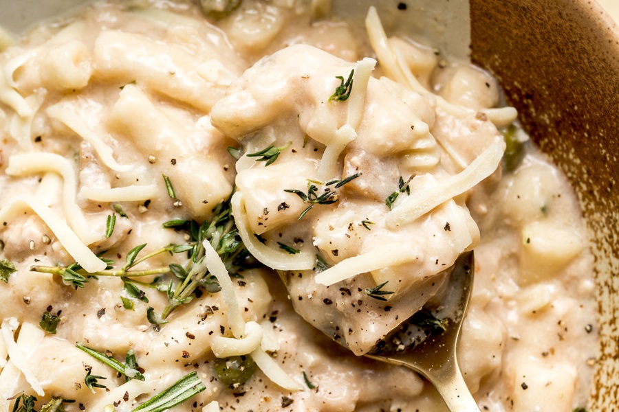 Easy Leftover Turkey and Noodles Recipe Close Up of a Spoonful of Casserole Sitting in a Bowl of Casserole